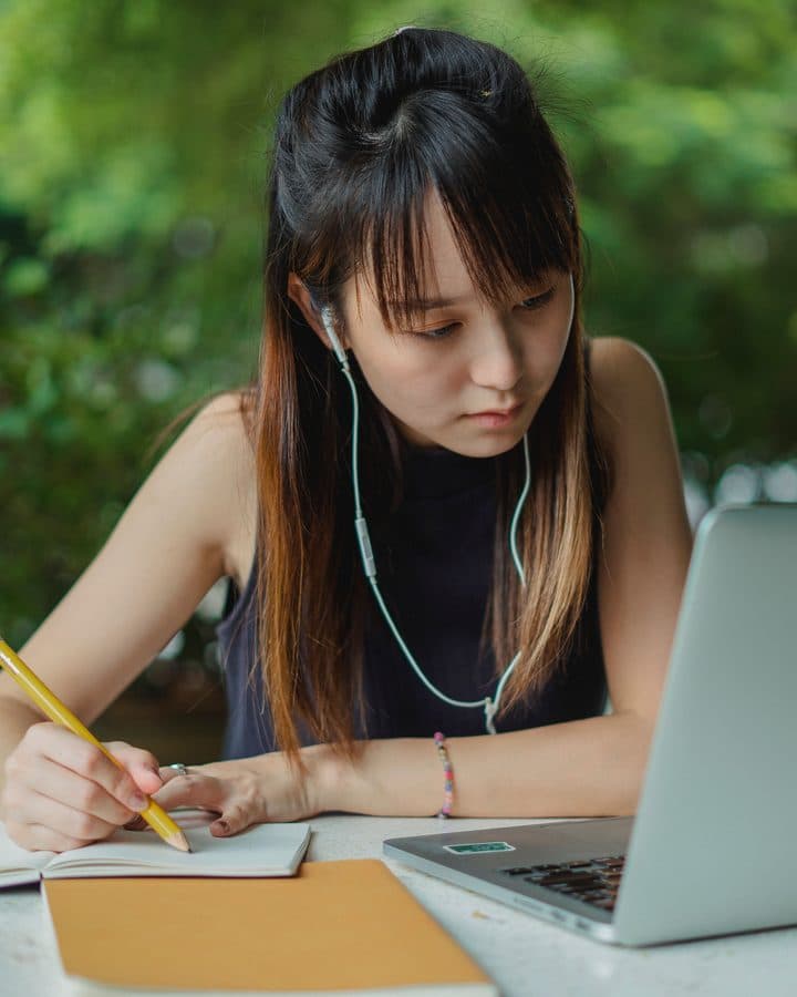 Siswa mengerjakan simulasi TOEFL dengan laptop dan earphone